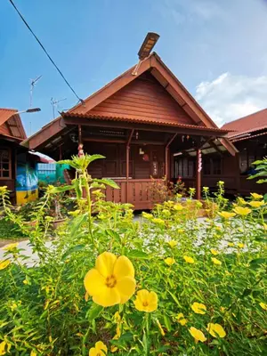 a house with a field of yellow flowers in front of it at Sekinchan 231 VA Chalet in Sekincan