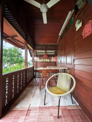 a room with a table and a chair on a porch at Sekinchan 231 VA Chalet in Sekincan