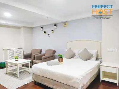 a bedroom with a bed and two chairs at Triima Inn Brinchang by Perfect Host in Brinchang