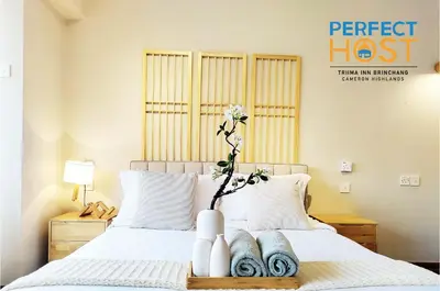 a bedroom with a bed with a vase with a flower on it at Triima Inn Brinchang by Perfect Host in Brinchang