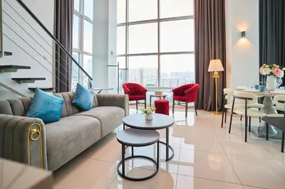 a living room with a couch and tables and chairs at Maritime Suite with Seaview 2BR - Water Dispenser - Dryer in George Town
