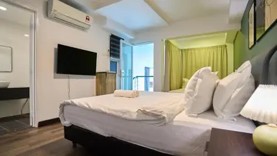 a bedroom with a bed with a television and a balcony at Maritime Suite with Seaview 2BR - Water Dispenser - Dryer in George Town