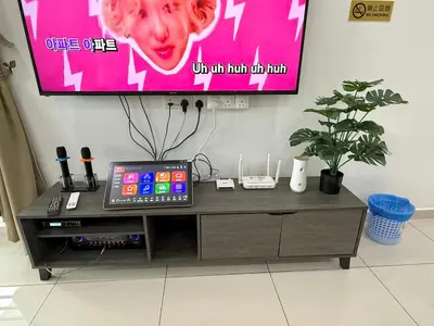 a television screen with a tablet sitting on a table at Sekinchan 2008 Homestay KaraokeBBQ 20pax \u4e09\u5c42\u7b80\u7ea6\u98ce\u540d\u5bbf in Sekincan