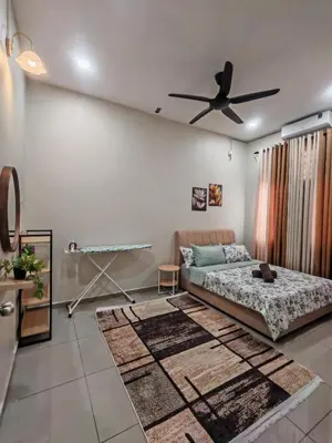 a living room with a bed and a ceiling fan at Seri Indah Homestay Bandar Baru Kuala Lipis in Kuala Lipis
