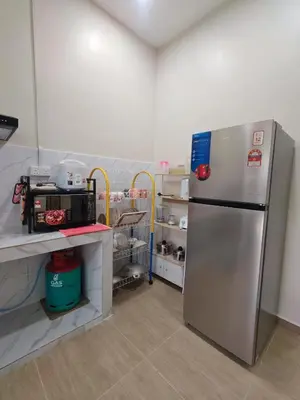 a kitchen with a stainless steel refrigerator in a room at Seri Indah Homestay Bandar Baru Kuala Lipis in Kuala Lipis