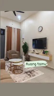 a living room with a couch and a tv and a table at Seri Indah Homestay Bandar Baru Kuala Lipis in Kuala Lipis