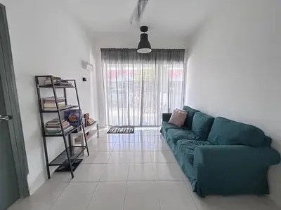 a living room with a green couch and a window at Homestay Rumah Raban in Kampong Kuala Chegar