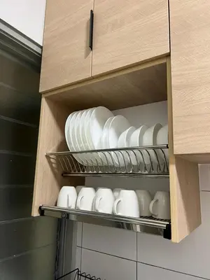a cupboard filled with white plates and bowls at Highland Chill Retreat in Tanah Rata