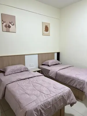 two beds in a room with purple blankets at Highland Chill Retreat in Tanah Rata