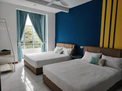 a bedroom with two beds and a blue wall at Hygee Home At Emerald Avenue Brinchang in Brinchang