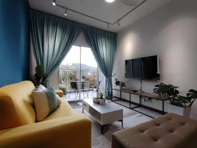 a living room with a yellow couch and a tv at Hygee Home At Emerald Avenue Brinchang in Brinchang