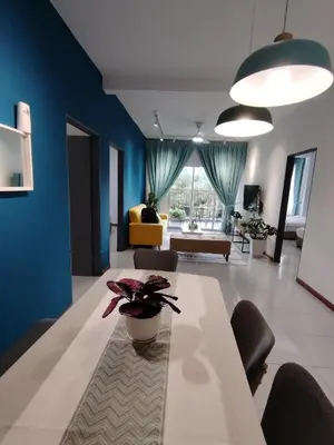 a living room with a table and a blue wall at Hygee Home At Emerald Avenue Brinchang in Brinchang