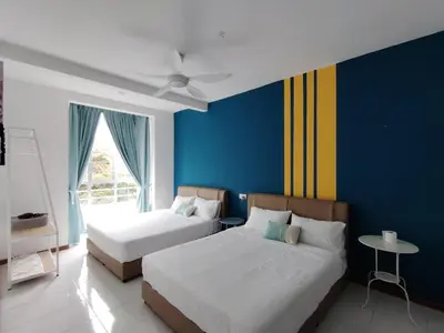 two beds in a room with blue and yellow walls at Hygee Home At Emerald Avenue Brinchang in Brinchang