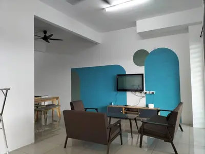 a living room with a blue wall and a table and chairs at Cozy 4 bedrooms Double Storey Homestay, in front Kulim Central Mall in Kulim