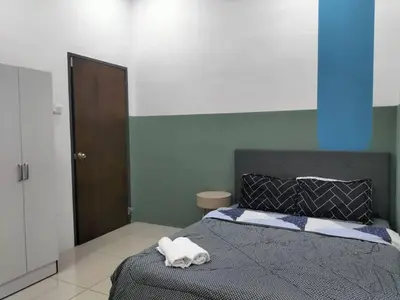 a bedroom with a bed with a towel on it at Cozy 4 bedrooms Double Storey Homestay, in front Kulim Central Mall in Kulim