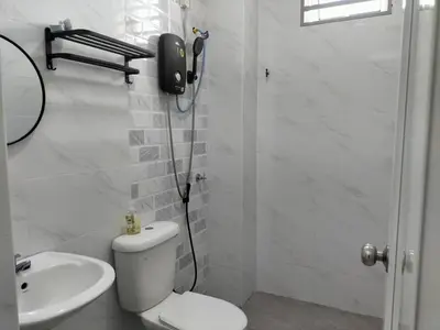 a white bathroom with a toilet and a sink at Cozy 4 bedrooms Double Storey Homestay, in front Kulim Central Mall in Kulim
