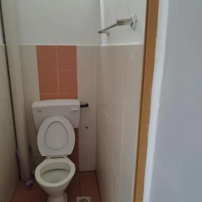 a small bathroom with a toilet and a faucet at Mastermind Kemboja Homestay in Sungai Petani