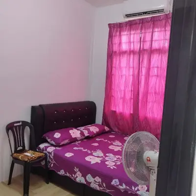 a bedroom with a bed with a fan and a pink curtain at Mastermind Kemboja Homestay in Sungai Petani