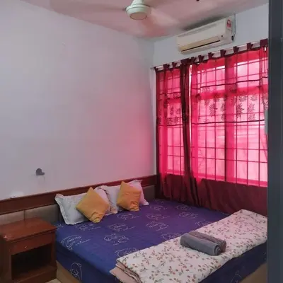 a bedroom with a bed and a window with pink at Mastermind Kemboja Homestay in Sungai Petani