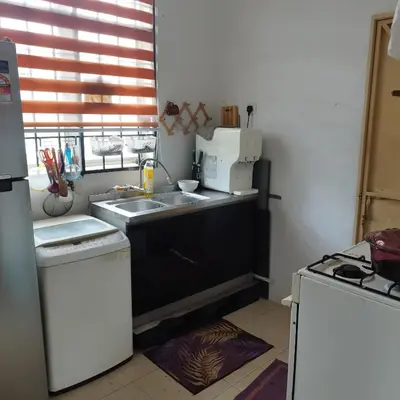 a kitchen with a sink and a refrigerator at Mastermind Kemboja Homestay in Sungai Petani