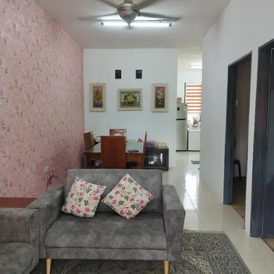 a living room with a gray couch with pillows at Mastermind Kemboja Homestay in Sungai Petani