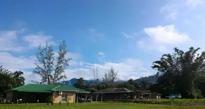 a house with a green roof in a field at GerchangLakeHouse in Behrang Hulu