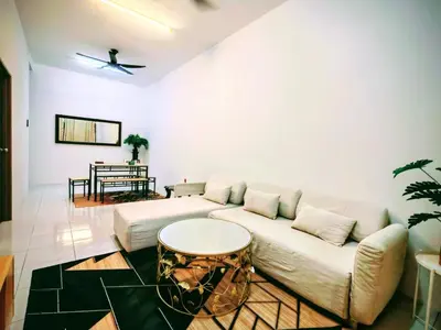 a living room with a white couch and a table at Myrol Homestay Padang Serai Kulim in Padang Serai