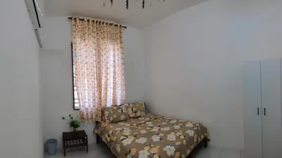 a bedroom with a bed and a window at Myrol Homestay Padang Serai Kulim in Padang Serai