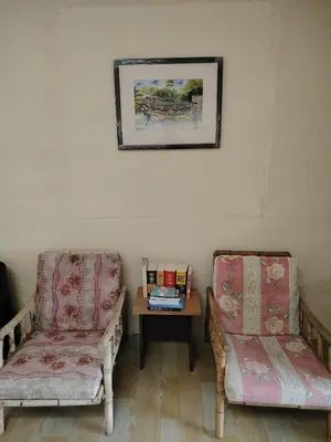 a room with two chairs and a table with books at Fantasy Stay Cameron Highlands in Kampung Kuala Terla