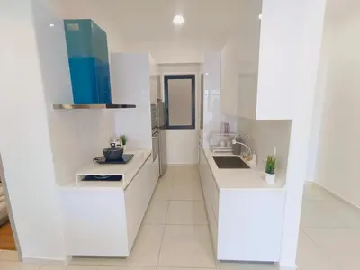 a white kitchen with white cabinets and a sink at Rooftop Pool, Up to 6 Pax, 2 Bedrooms, 2 Bathrooms, 2 Car Parks by Star Home in George Town