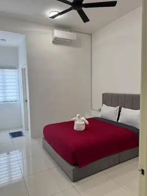 a bedroom with a large red bed with a ceiling fan at Ramadhina The Luxe Retreat Home2stay Ipoh in Ipoh