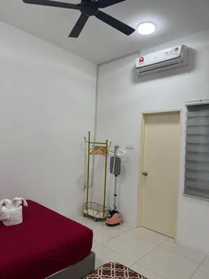 a bedroom with a ceiling fan and a red bed at Ramadhina The Luxe Retreat Home2stay Ipoh in Ipoh