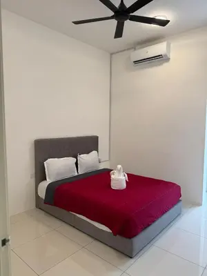a bedroom with a red bed with a ceiling fan at Ramadhina The Luxe Retreat Home2stay Ipoh in Ipoh