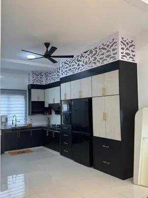 a kitchen with black cabinets and a ceiling fan at Ramadhina The Luxe Retreat Home2stay Ipoh in Ipoh