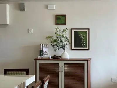 a dining room with a table and a vase on a cabinet at Moriash Stay in Brinchang