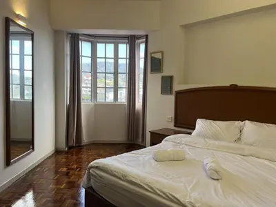 a bedroom with a large white bed and two windows at Moriash Stay in Brinchang