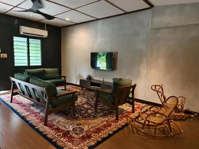 a living room with a couch and chairs and a tv at Rumah Atuk Homestay in Gua Musang