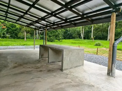 a concrete bench sitting under a metal roof at Rumah Atuk Homestay in Gua Musang