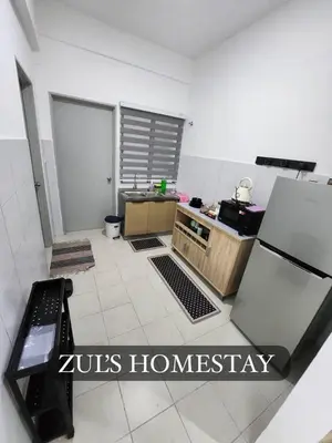 a small kitchen with a refrigerator and a counter at Zuls Apartment Homestay Cameron Highlands in Tanah Rata