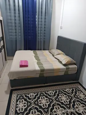a bed sitting in a room with a rug at FH Homestay Kuala Lipis 3R2B in Kuala Lipis