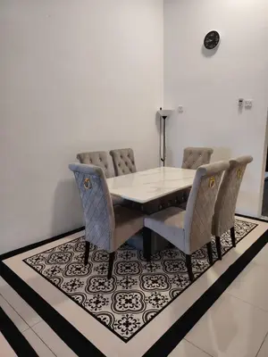 a dining room with a table and chairs on a rug at FH Homestay Kuala Lipis 3R2B in Kuala Lipis