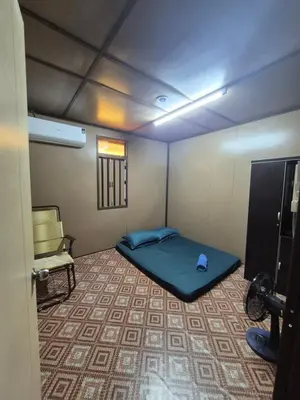 a small room with a bed and a chair at Homestay Sayang Salmah in Balik Pulau