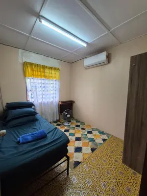 a bedroom with a blue bed and a window at Homestay Sayang Salmah in Balik Pulau