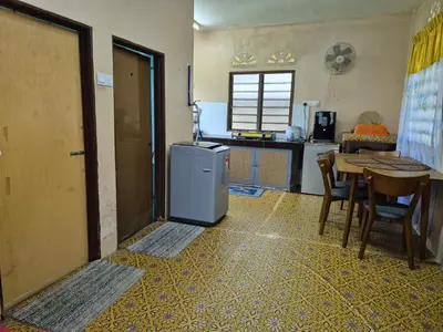 a kitchen with a table and a small refrigerator at Homestay Sayang Salmah in Balik Pulau