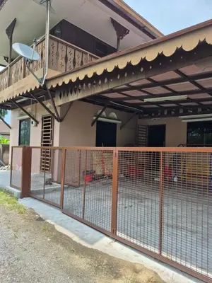 a fence in front of a house with a balcony at Homestay Sayang Salmah in Balik Pulau