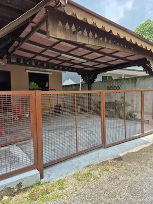 a wooden fence with a pergola in front of a house at Homestay Sayang Salmah in Balik Pulau
