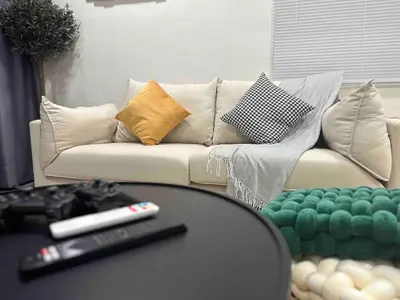 a living room with a couch and a remote control at Moonine Homes Taiping in Kamunting