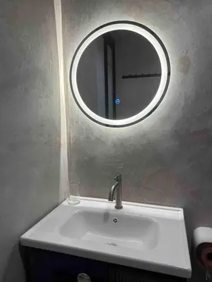 a bathroom sink with a round mirror above it at Moonine Homes Taiping in Kamunting