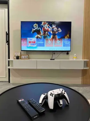 a table with a video game controllers and a tv at Moonine Homes Taiping in Kamunting