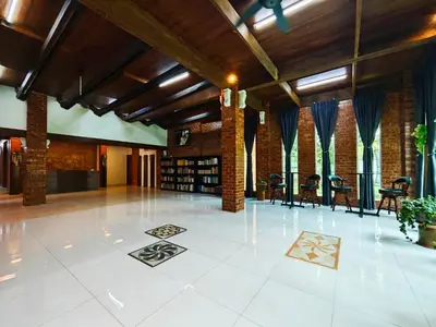 a large room with tables and chairs in a building at DAWA Brickhouse - Balinese Guesthouse in Thompson Ipoh by Ryokan Management in Ipoh